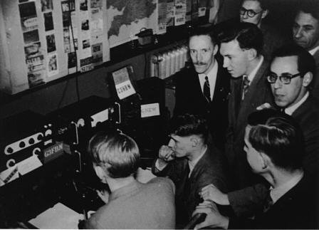 The picture shows enthusiastic Club members gathered around the radio at the Kodak exhibition. We recognise a couple of people in this picture: the chap with the moustache is Peter Parry, G3KOE; and the chap standing to Peter's front is Brian Hummerstone, G3HBR.